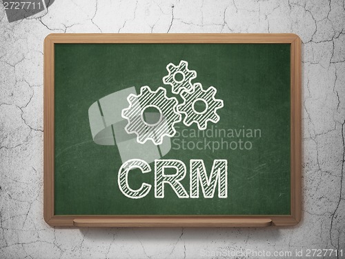 Image of Business concept: Gears and CRM on chalkboard background