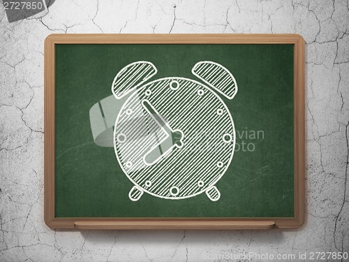 Image of Time concept: Alarm Clock on chalkboard background