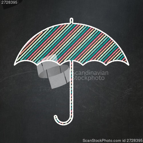 Image of Safety concept: Umbrella on chalkboard background