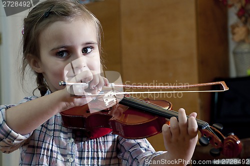 Image of adorable little girl learning violin playing