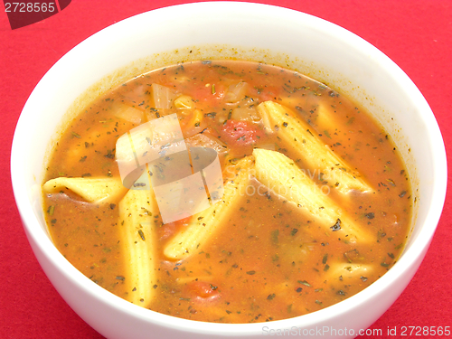 Image of Noodle soup with tomatoes and herbs on red