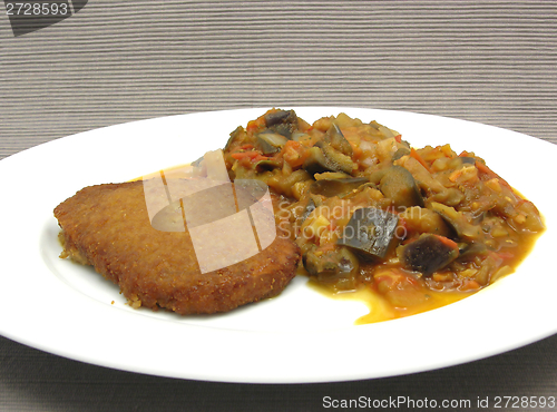 Image of Breaded bean curd cutlet with fried vegetable on a white plate