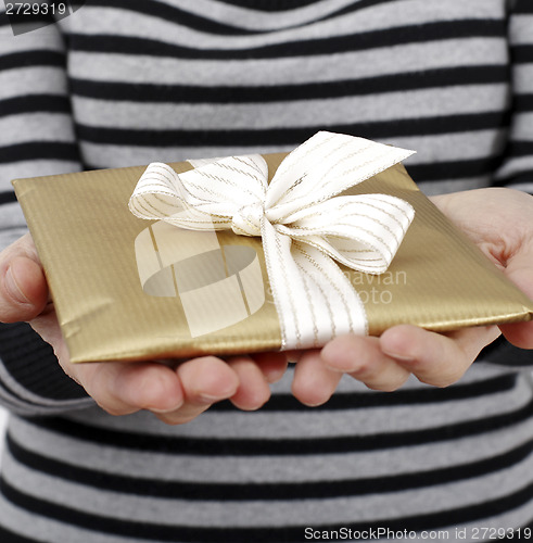 Image of Young woman holding a present