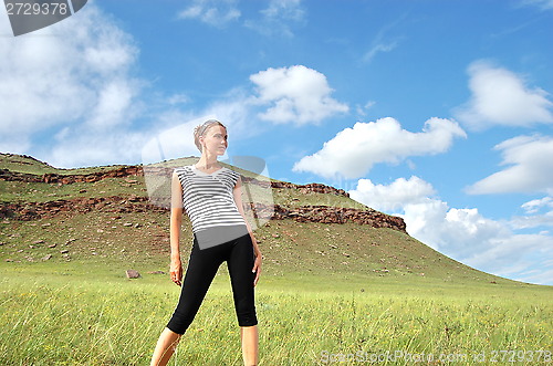 Image of Woman in striped vest on a background of mountain herbs.