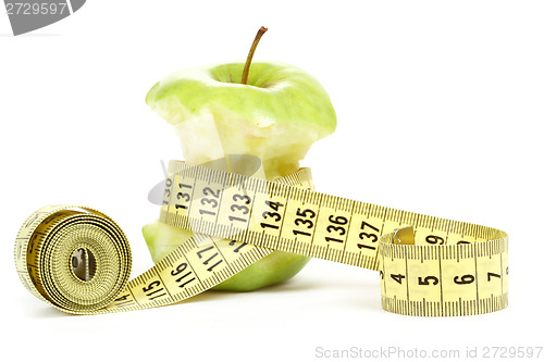 Image of Green bitten apple isolated on white with measuring tape