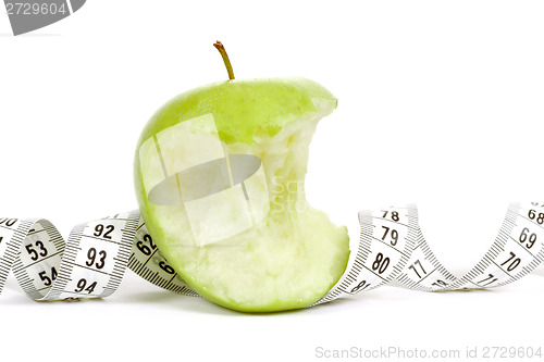 Image of Green bitten apple isolated on white with measuring tape