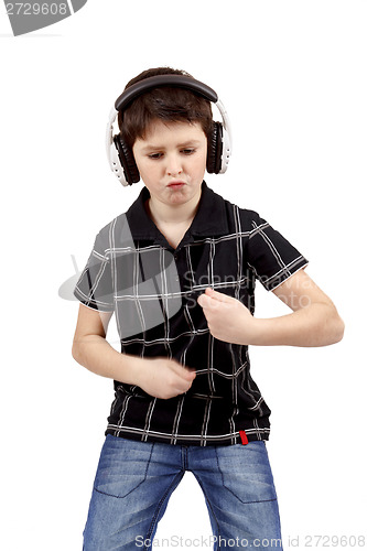 Image of Portrait of a happy young boy listening to music and dancing