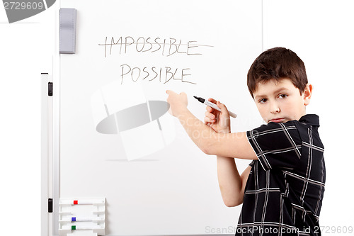 Image of young boy student in a writing on a whiteboard