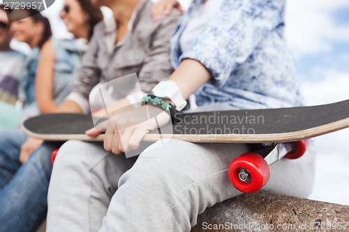 Image of close up of female hand holding skateboard