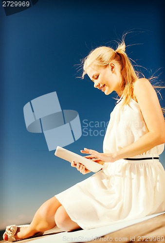 Image of beautiful smiling woman with tablet pc outdoors