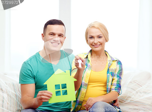 Image of couple with green house and keys in new home