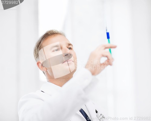 Image of male doctor holding syringe with injection