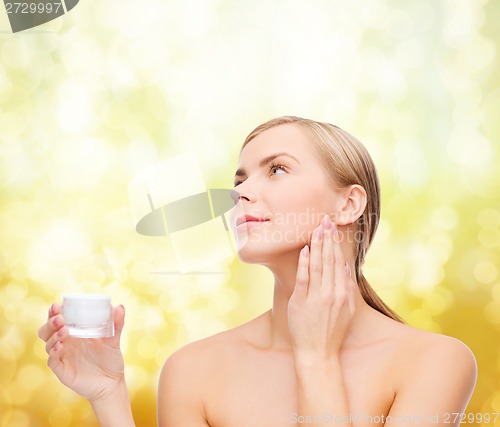 Image of woman applying cream on her skin