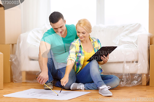 Image of smiling couple looking at bluepring in new home