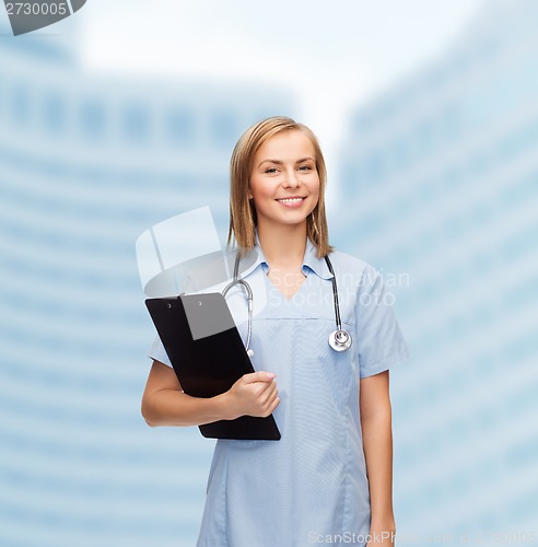 Image of smiling female doctor or nurse with clipboard