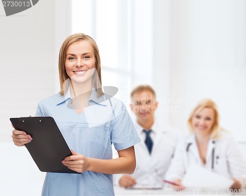 Image of smiling female doctor or nurse with clipboard