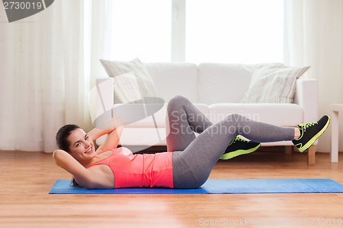 Image of smiling girl doing exercise on floor at home