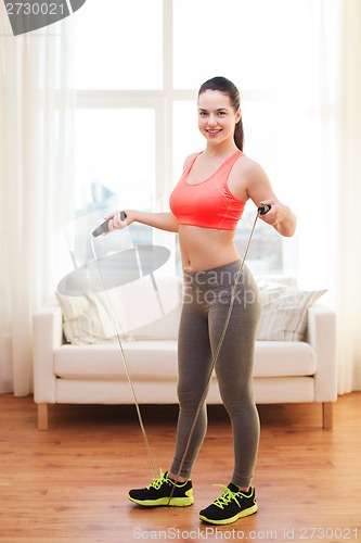 Image of smiling teenage girl with skipping rope at home