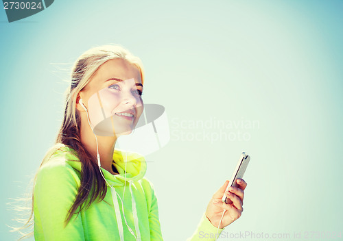 Image of woman listening to music outdoors