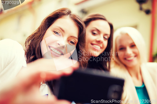 Image of beautiful girls taking picture in cafe in city