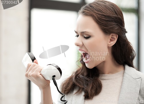 Image of angry businesswoman shouting at phone