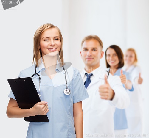 Image of smiling female doctor or nurse with clipboard