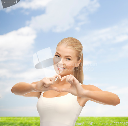 Image of smiling woman showing heart shape gesture