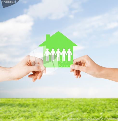 Image of man and woman hands with paper house