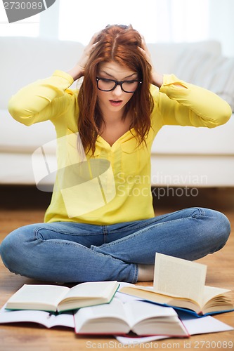 Image of smiling student girl reading books at home