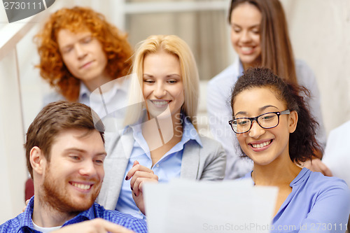 Image of team with papers and take away coffee on staircase