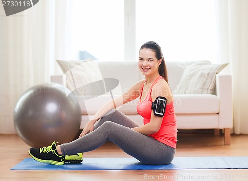 Image of smiling girl with armband execising at home