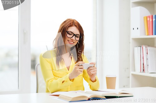 Image of smiling student girl with smartphone at school