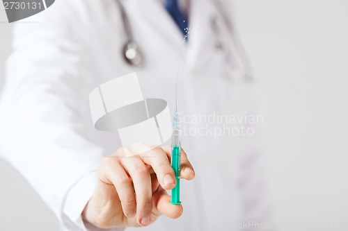 Image of male hand holding syringe with injection