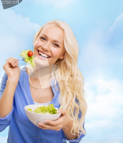 Image of smiling young woman with green salad