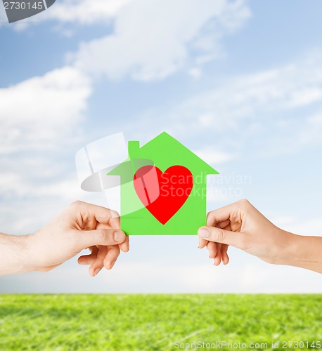 Image of couple hands holding green paper house