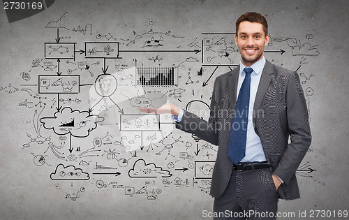 Image of man showing something big plan on concrete wall