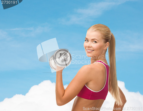 Image of smiling woman with heavy steel dumbbell