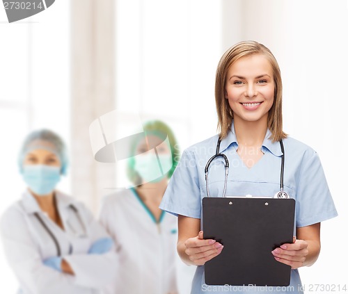 Image of smiling female doctor or nurse with clipboard