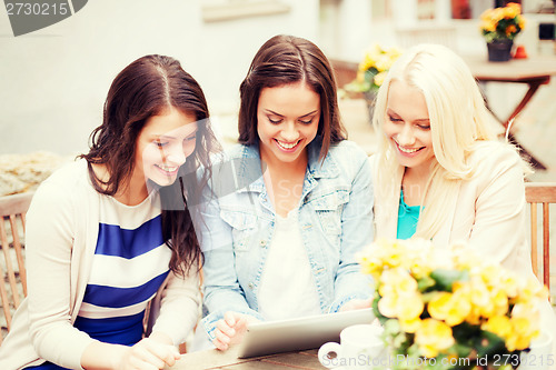 Image of beautiful girls looking at tablet pc in cafe