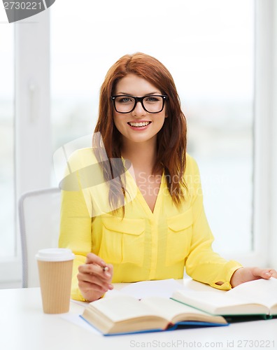 Image of smiling student girl reading books in library