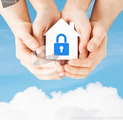 Image of hands holding paper house with lock