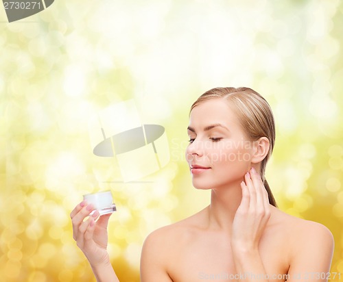 Image of woman applying cream on her skin