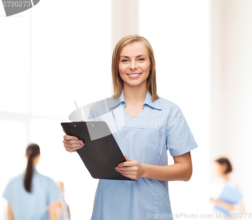 Image of smiling female doctor or nurse with clipboard