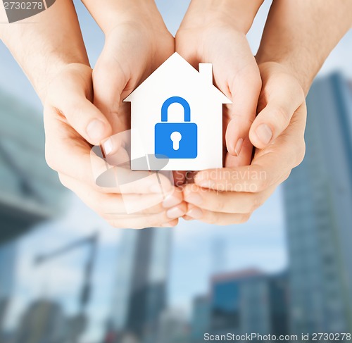 Image of hands holding paper house with lock