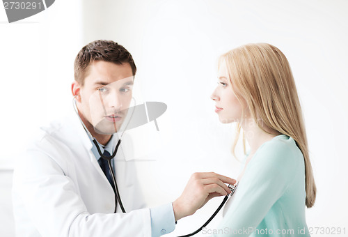 Image of doctor with stethoscope listening to the patient