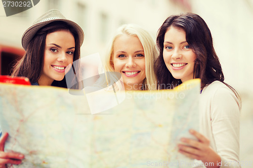 Image of beautiful girls looking into tourist map in city