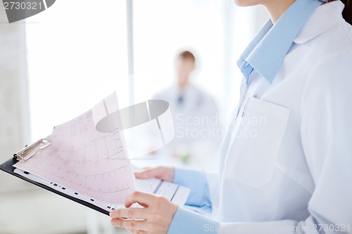 Image of female holding clipboard with cardiogram