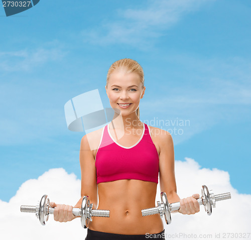 Image of woman with heavy steel dumbbells