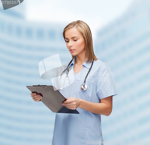 Image of smiling female doctor or nurse with clipboard