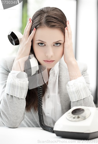 Image of stressed and tired businesswoman with cell phone